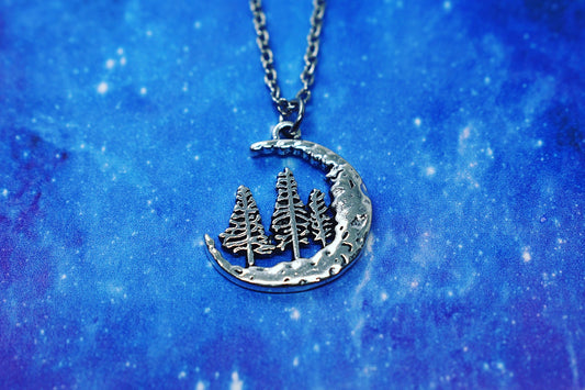 Necklace with crescent moon pendant and three fir trees