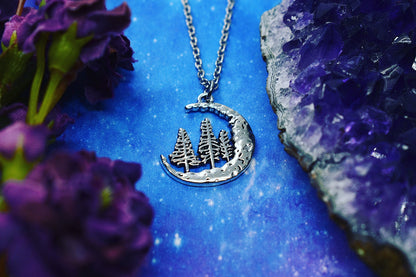 Necklace with crescent moon pendant and three fir trees